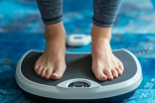Bare feet standing on a digital scale on a blue rug, showing an athlete cutting weight for BJJ tournament preparation.