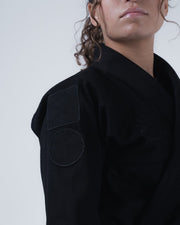 Kingz Born to Rule Women's Jiu Jitsu Gi Black - Close-Up Shoulder View Black Patch Detail Textured Fabric Elegant Stitching BJJ Gi Training [color:Black]