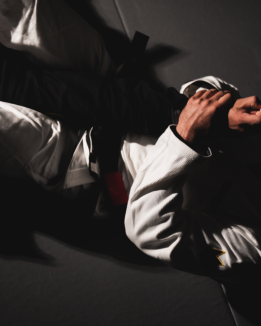 Close-up of an athlete grappling in the white Kingz Comp 450 V7 jiu jitsu gi