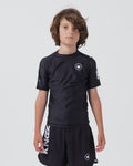 Kingz Kore V2 Youth S/S Rashguard Navy Black - Full Body Front View Teen Boy Athlete Short Sleeve Navy Blue Minimal Design White Crown Logo Circle Chest KINGZ White Sleeve Text Matching Navy Shorts Crown Logo Hem Kids BJJ Training