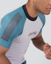 Kingz Flow Rashguard Blue/Pink - Close-Up View Male Athlete Blue Sleeves White Body Wavy Line Pattern KINGZ Text Chest Black Collar Contrast Stitching BJJ Grappling Rash Guard [color:Black]