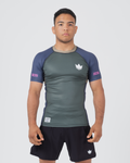 Kingz Draft Rashguard Storm Blue - Full Body Front View Male Athlete Short Sleeve Gray Charcoal Body Blue Raglan Sleeves White Crown Logo Pink KINGZ Labels Crown Badge Black Shorts