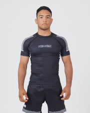 Kingz Flow Rashguard Black - Full Body Front View Male Athlete Short Sleeve Black with Silver KINGZ Text Chest Geometric Shoulder Pattern Snug Fit BJJ Grappling Rash Guard [color:Black]