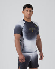 Kingz Galaxy Rash Guard Black White - Full Body Front View Male Athlete Short Sleeve Black To White Ombre Galaxy Spatter Pattern KINGZ Gold Text Gold 4-Point Star Crown Logo Matching Galaxy Shorts BJJ Training Compression Fit [color:Black/Galaxy]