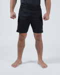 Kingz Player Special Limited Edition Shorts Black Gold - Full Body Front View Male Athlete All-Black KINGZ Gold Text Left Leg Gold Crown Badge Right Thigh Black Elastic Waistband Competition Cut Men's Grappling Shorts No-Gi BJJ Tainan Dalpra Signature Collection