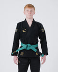 Kingz Comp V6 Youth BJJ Gi Black - Upper Body Front View Teen Athlete Teal Belt HEAVY LIES THE CROWN Patch Gold Crown Logo 450gsm