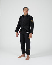 Kingz Legends Never Die Respect Women's Gi - Black - Full Body Front View Female Athlete Black Gi Yellow Crown Sleeve Patch Embroidered Text Pants Durable Fabric BJJ Training Gi [color:Black]