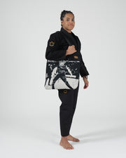 Kingz Legends Never Die Respect Women's Gi - Black - Full Body Side View Female Athlete Black Gi Gold Crown Logo Sleeve Embroidered Patch Graphic Tote BJJ Training Gi [color:Black]
