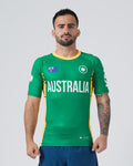 Kingz Jersey Rashguard Australia Edition - Full Body Front View Male Athlete Short Sleeve Green Body AUSTRALIA White Bold Text Australian Flag Patch White Crown Logo Yellow Gold Collar Yellow Side Stripes BJJ National Pride MMA